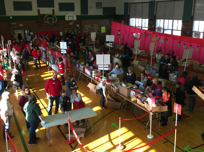 Shoppers and volunteers fill the gym. 