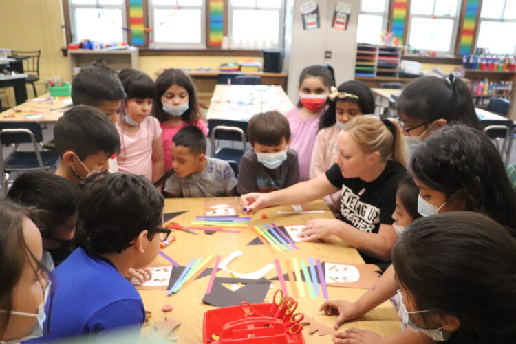 Ms. Johnston shows 1st graders how to make a rainbow wizard. 